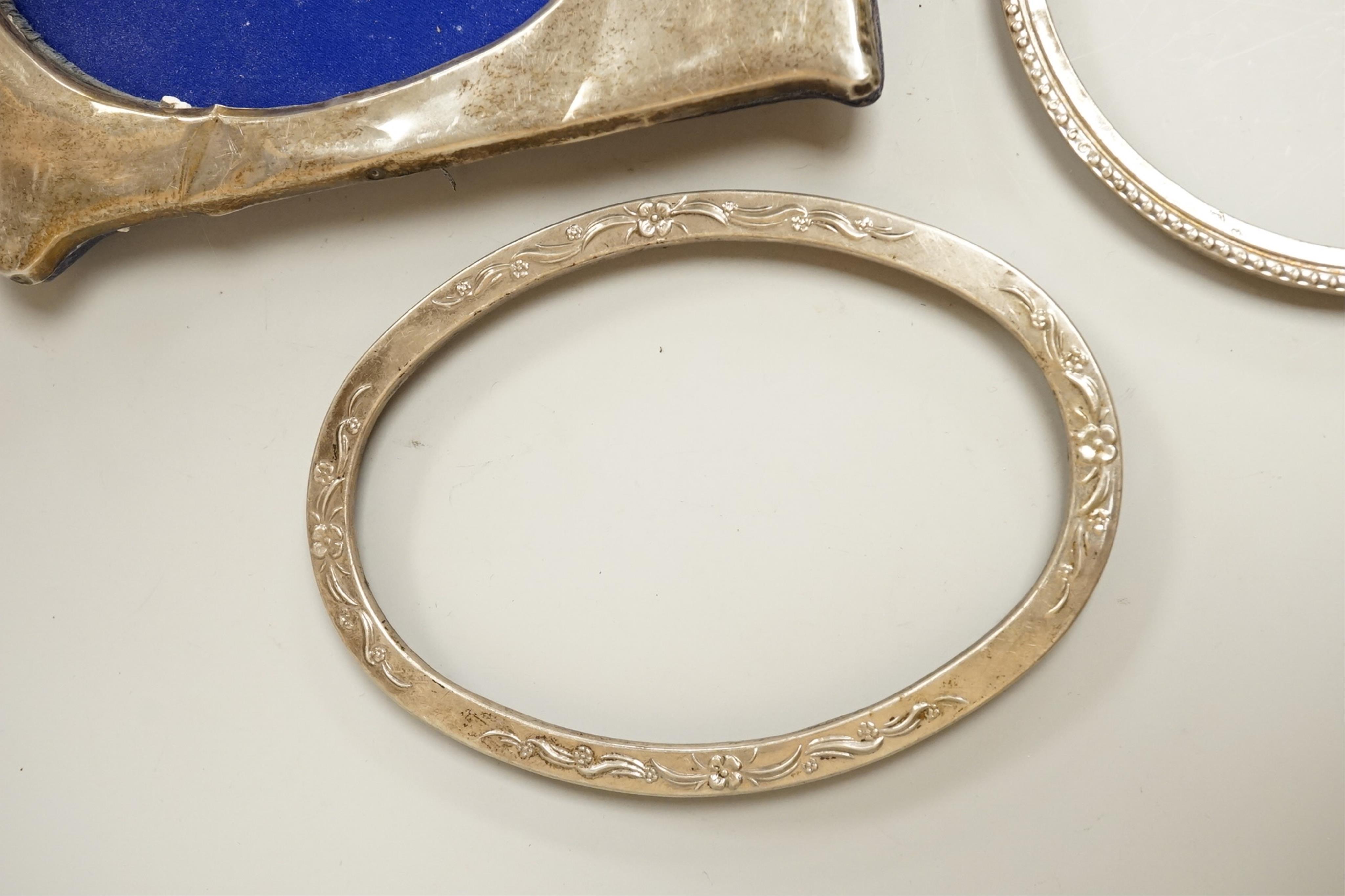 Four assorted early 20th century silver mounted photograph frames, the largest by Sanders & Mackenzie, Birmingham, 1915, 30.3cm by 21.6cm, together with two small Spanish white metal mounted photograph frames.